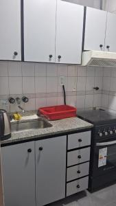 a kitchen with white cabinets and a sink and a stove at Depto 1 ambiente in Mar del Plata