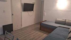 a room with a bed and a flat screen tv at Depto 1 ambiente in Mar del Plata