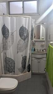 a bathroom with a shower curtain with two umbrellas at Depto 1 ambiente in Mar del Plata +9 photos
