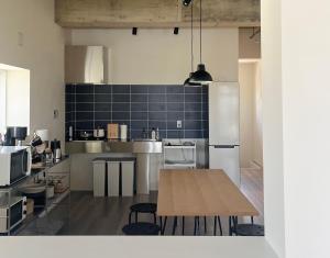 a large kitchen with a wooden table in it at カリマタテラス宮古島 in Miyako-jima