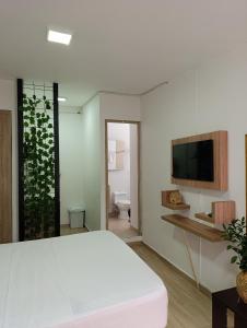 a bedroom with a bed and a tv on a wall at Apartahotel Provenza 2 in Medellín