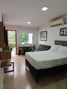 a bedroom with a bed and a living room at Apartahotel Provenza 2 in Medellín