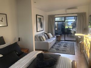 a living room with a couch and a table at Hamurana Roost in Rotorua +18 photos