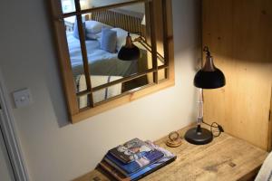 a bedroom with a mirror and a lamp on a table at The Dolphin Inn in Thorpeness