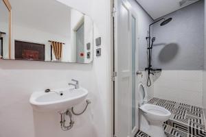 a white bathroom with a sink and a toilet at RedDoorz Syariah Plus at Limus Nunggal in Bahom +20 photos