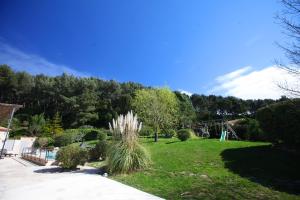 a grassy yard with a playground in the background at Villavos- La Vassal in Cassis