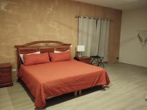 a bedroom with a bed with orange sheets and pillows at Enjoy Mérida at Casa Cambas in Mérida
