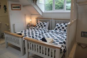 a bedroom with two beds and a window at Tide House Seaside Holiday Cottage in Shaldon