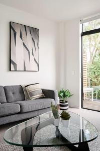 a living room with a couch and a glass table at Architectural Urban Diamond in Christchurch