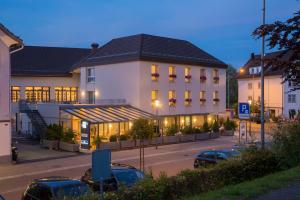 un edificio con coches estacionados frente a él en Hotel Hecht, en Rheineck