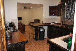 a kitchen with a table and a counter top at Charming Self Catering Apartment in Phalaborwa