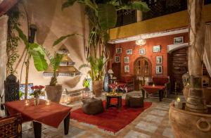 eine Lobby mit Tischen und Pflanzen in einem Gebäude in der Unterkunft Riad Eden in Marrakesch