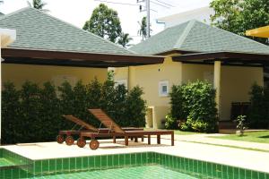 a house with a pool and two lounge chairs next to it at Blue Wave Samui in Bophut 