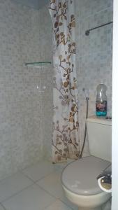 a bathroom with a toilet and a shower curtain at Yamara's somente mulheres in Manaus