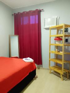 a bedroom with a bed and a ladder and a red curtain at Yamara's somente mulheres in Manaus