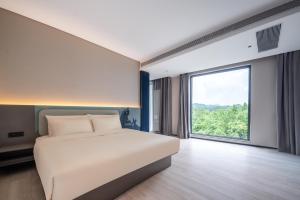 a bedroom with a large bed and a large window at Atour Light Hotel Guangzhou Panyu Hanxi Changlong-Free Midnight Snack&16 minutes drive to Conton Fair&Free Coffee Togo&Free Laundry and Drying services in Guangzhou
