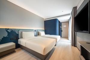 a hotel room with two beds and a flat screen tv at Atour Light Hotel Guangzhou Panyu Hanxi Changlong-Free Midnight Snack&16 minutes drive to Conton Fair&Free Coffee Togo&Free Laundry and Drying services in Guangzhou +58 photos