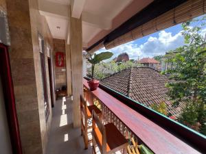 a balcony with a view of a roof at ERA Guest House in Ubud