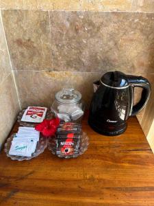 a table with a coffee maker and a tea kettle at ERA Guest House in Ubud