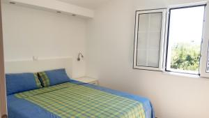 Schlafzimmer mit einem Bett und einem Fenster in der Unterkunft Apartment MilaS in Tivat