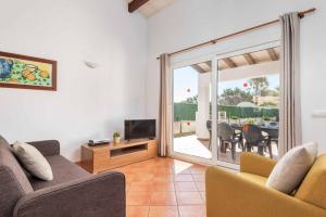a living room with a couch and a television at Villa Aguasol in Cala en Forcat