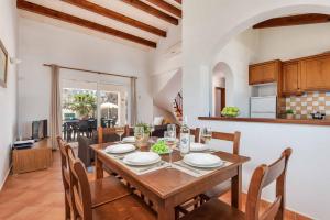 a kitchen and dining room with a table and chairs at Villa Aguasol in Cala en Forcat
