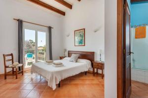 a white bedroom with a bed and a window at Villa Aguasol in Cala en Forcat +23 photos
