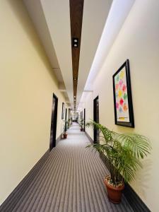 a corridor of an office building with potted plants at Hotel Taj Metro in Maulvi Bāzār