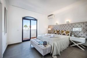 a white bedroom with a large bed and a window at Villa Marquesa in Guia +26 photos