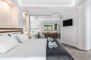 a bedroom with a bed with two pairs of slippers at Villa Summer Dawn in Kiotari +20 photos