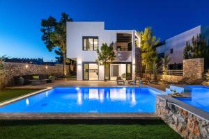 a swimming pool in front of a house at night at Villa Summer Dawn in Kiotari