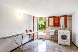 a laundry room with a washing machine and a window at Villa Voltor Cinco in Pollença