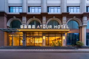 武漢市にあるAtour Hotel Wuhan Jianghan Road Jiangtanのアトリウムホテルの外観を望めます。