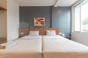バンドンにあるHotel Ersada Bragaの窓のある寝室にベッドが2つある