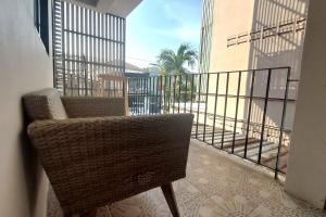 a rattan chair sitting on a balcony with a view at Sukhum Suvarnabhumi Airport Guest House in Ban Klong Plad Kriang