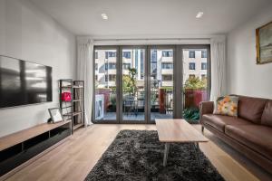 a living room with a couch and a table at Modern Stay Opposite North Hagley Park & Casino in Christchurch