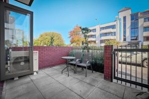a patio with a table and chairs and a building at Modern Stay Opposite North Hagley Park & Casino in Christchurch