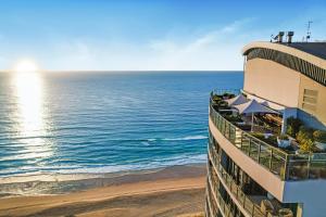 a building on the beach next to the ocean at Amazing Ocean View Apartment in Surfers Paradise in Gold Coast