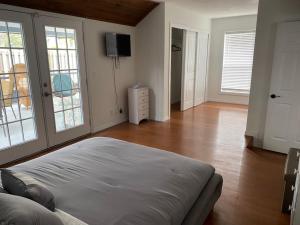 Una sala de estar con una cama y un televisor. en Relaxing 3 bed 2 bath Wifi by the Intercostal, en Daytona Beach