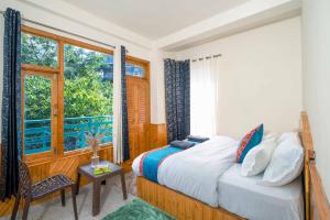 een slaapkamer met een bed en een raam bij 360 Degree Kasol in Kasol