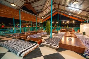 een kamer met tafels en stoelen op een geruite vloer bij 360 Degree Kasol in Kasol