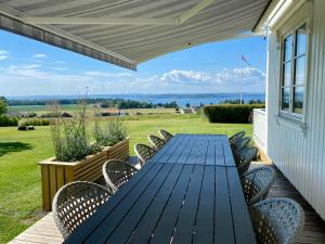 a blue table and chairs on a deck with a view at Enjoy Views In Helgeroa, Near The Beach in Helgeroa