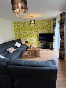 a living room with a blue couch and a yellow wall at The Olive Villa in Manchester