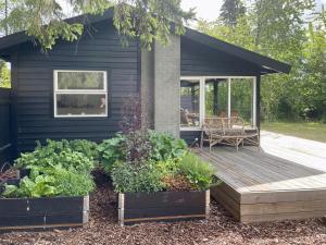 a house with a wooden deck and some plants at Charming Cottage Close To Smidstrup Beach in Gilleleje
