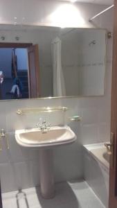 a bathroom with a sink and a mirror and a tub at Casa Turistica Termas aparcamiento y desayuno incluido in Merida +25 photos