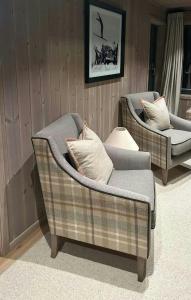 two chairs and a couch in a room at Premium Cabin By Kvitfjell Ski Slopes in Ringebu