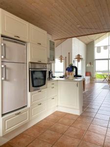 eine Küche mit weißen Schränken und einer Arbeitsplatte in der Unterkunft Summer House With Panoramic View Near Doverodde in Doverodde