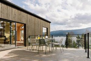 a dining room with a table and chairs on a deck at Designer Cabin By Lake Nisser With View And Sauna in Treungen
