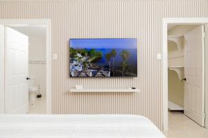 a bedroom with a tv hanging on a wall at Spacious Comfort - Kingston in Kingston