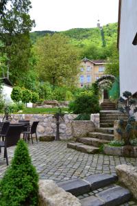 a stone patio with a table and chairs and a building at Casa Veche in Braşov